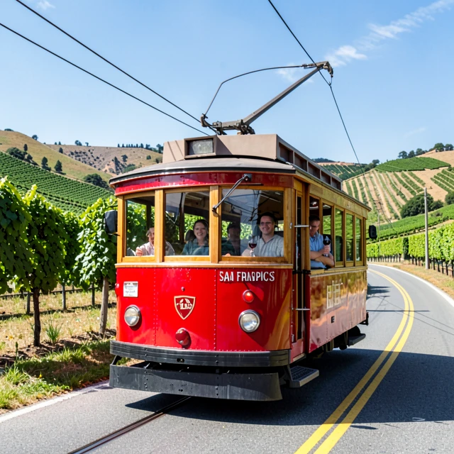 Open-air Napa Valley Wine Trolley cruising through vineyards on a sunny day