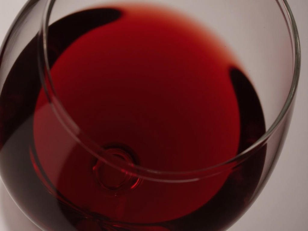 Examining the color of red wine in a glass.